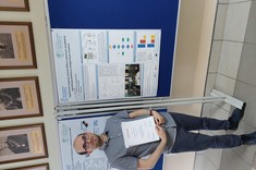 Inż. Jakub Drzał na tle swojego plakatu,