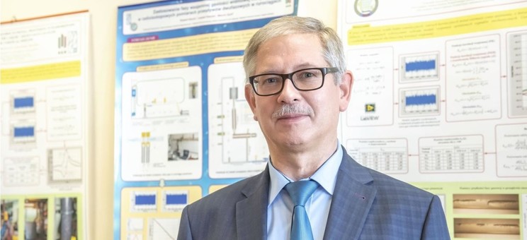 Prof. dr hab. inż. Robert Hanus na tle plakatów naukowych pracowników KMiSD. 